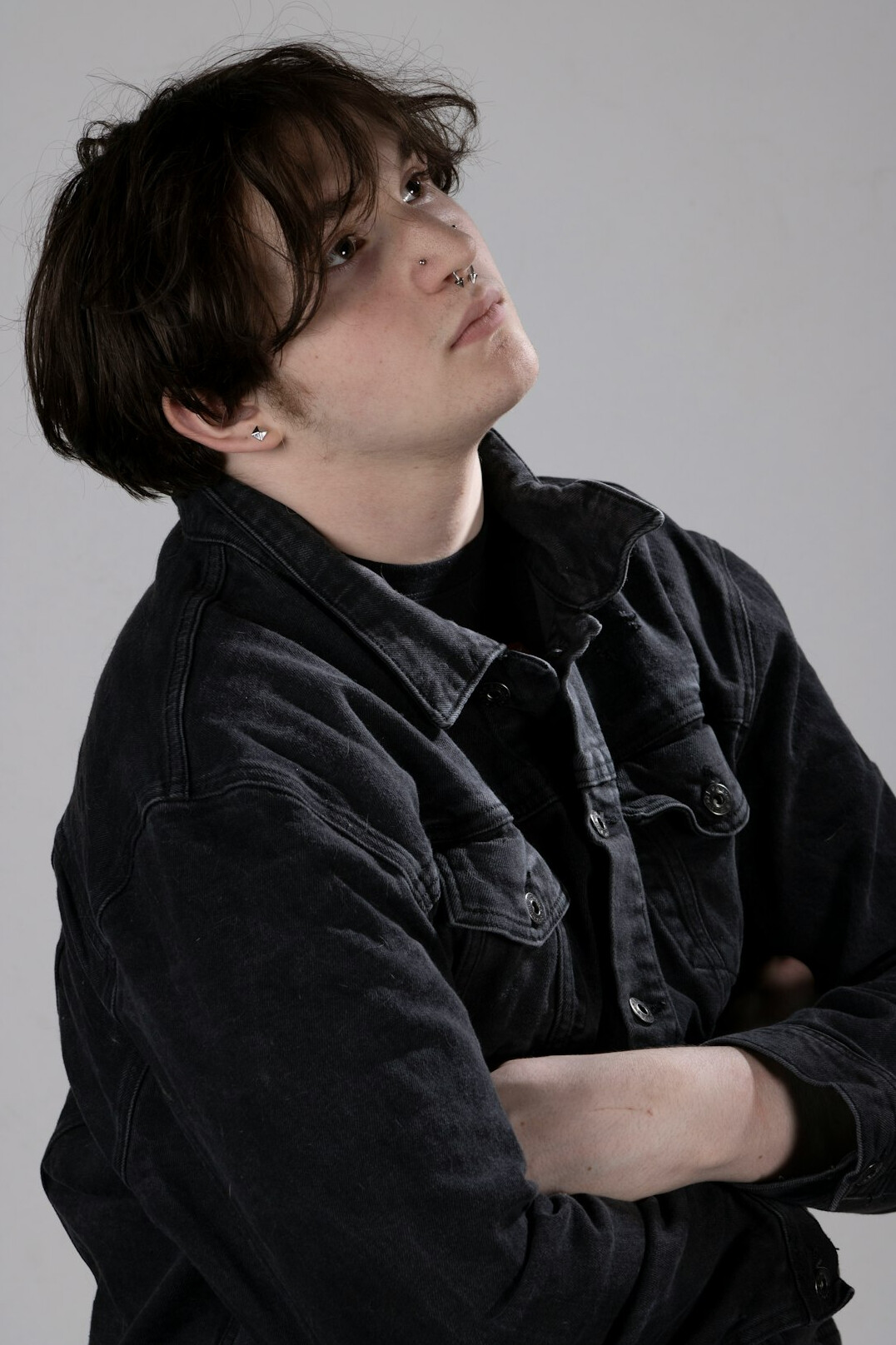 Portrait of a man with short dark hair in a charcoal jacket against a neutral background