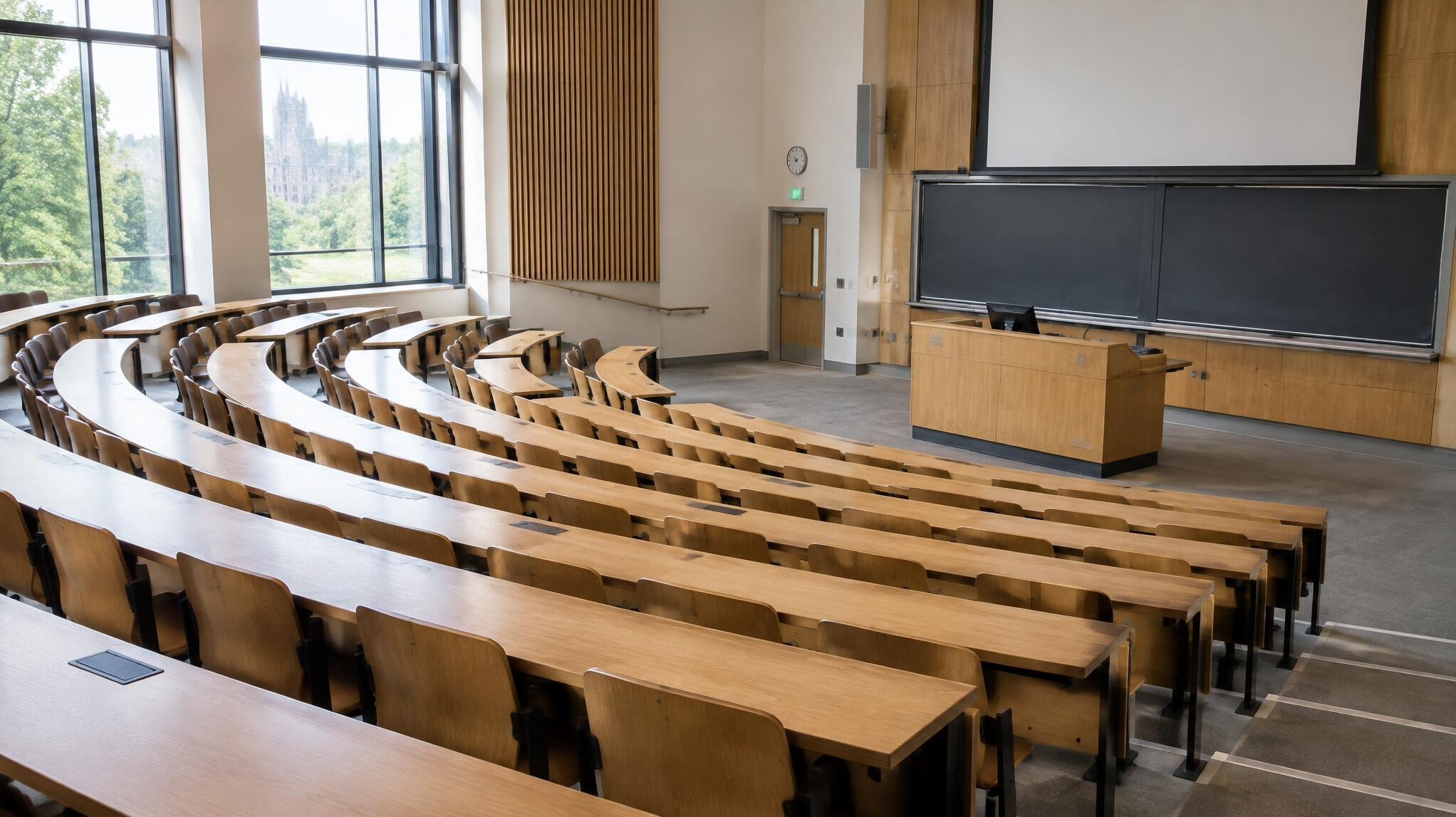 Empty university lecture hall with rows of wooden seats
